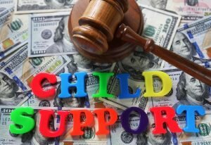 Child Support spelled out with gavel on top of cash
